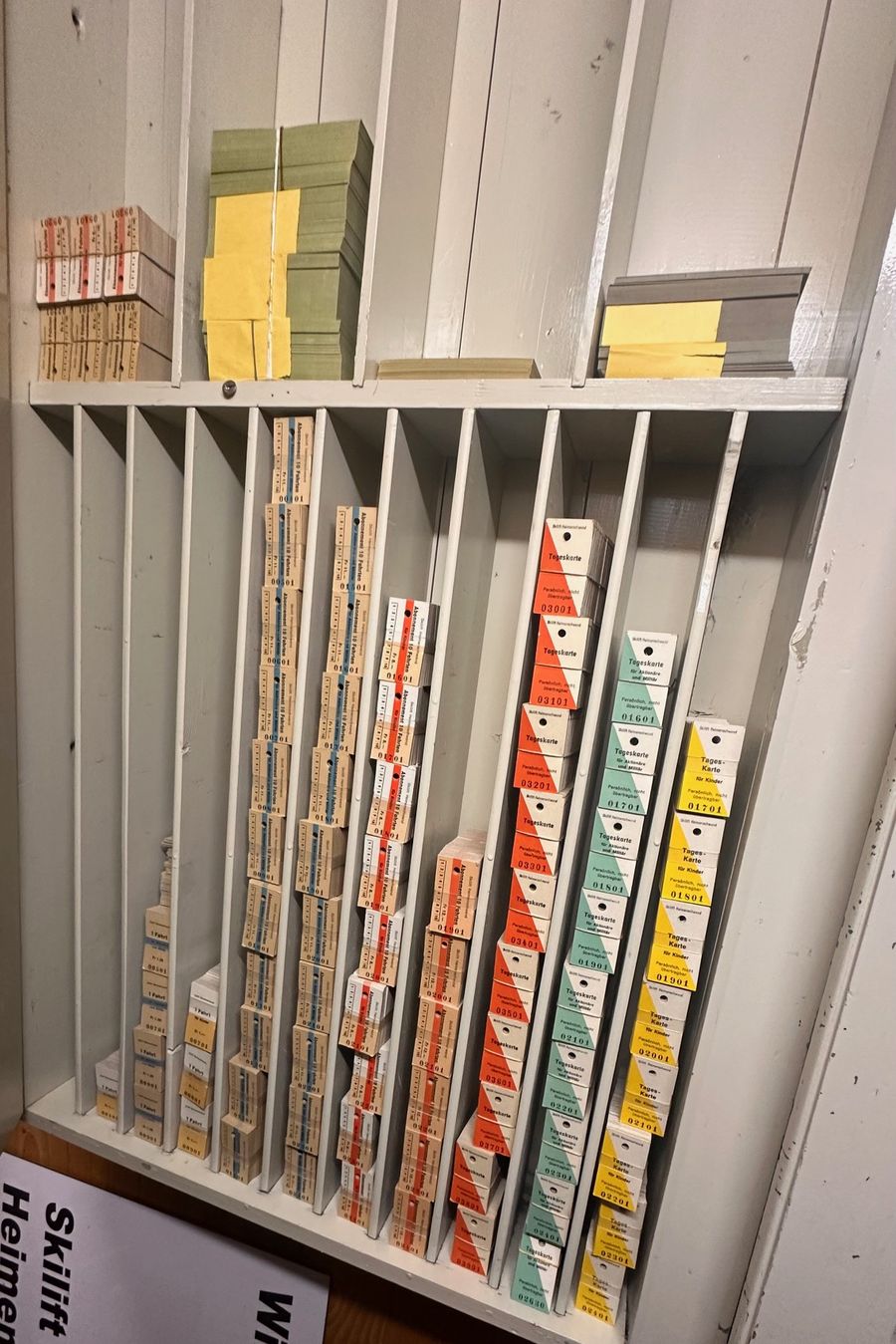 Holzregal mit gestapelten Tageskarten, Abos und Kinderkarten