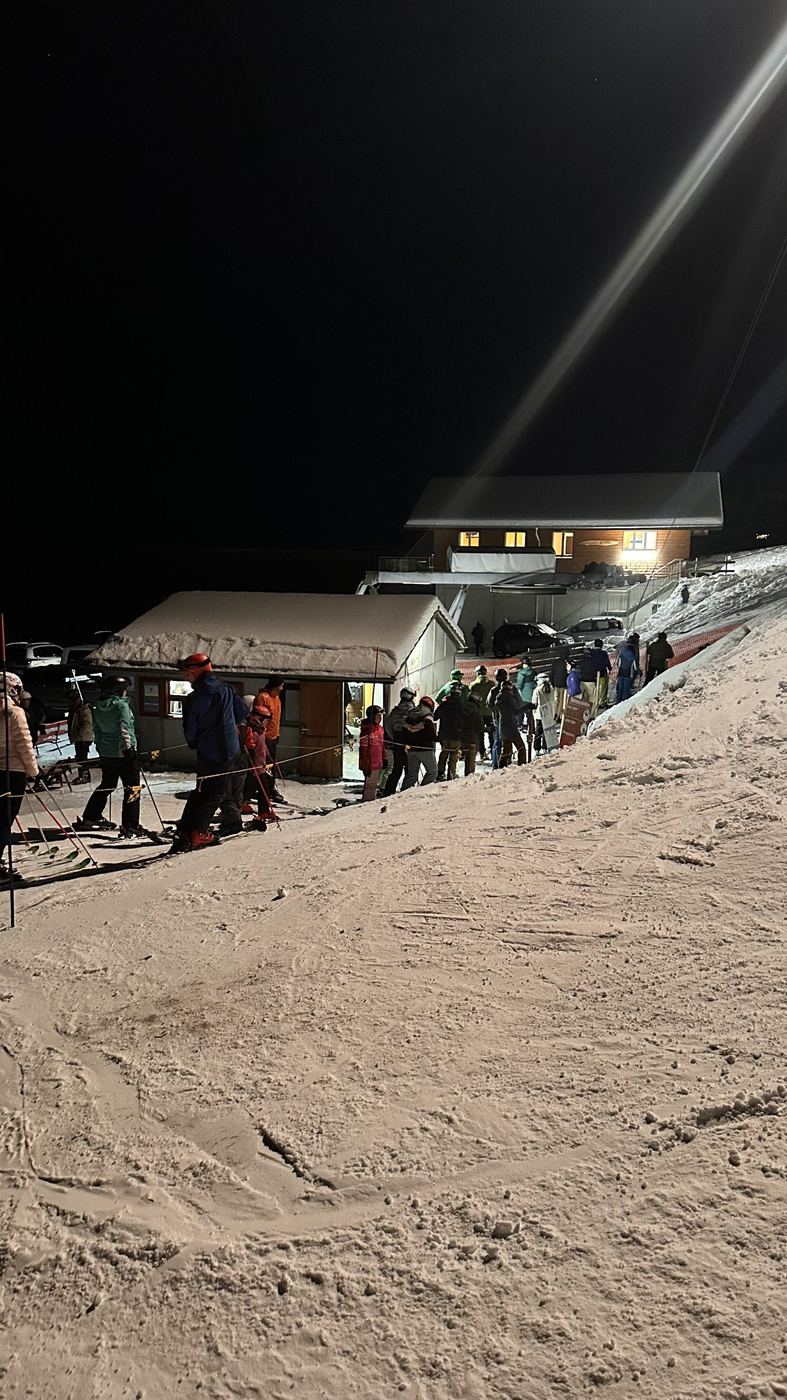 Schlange vor dem beleuchteten Kassenhäuschen am Abend