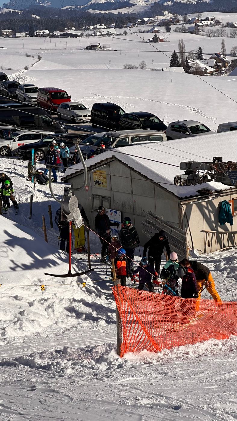 Familien und Kinder warten an der Talstation auf den Bügel