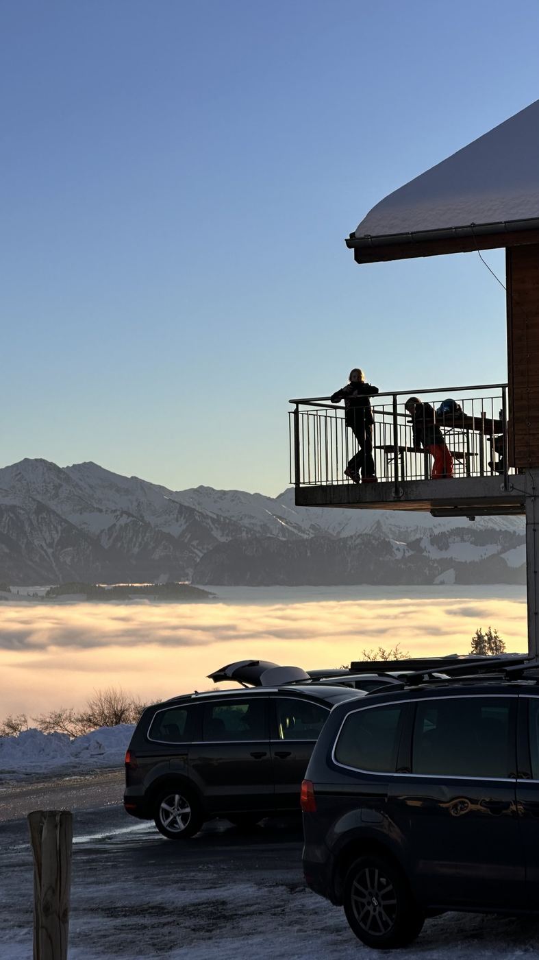 Kinder auf der Terrasse im Abendlicht über dem Nebel