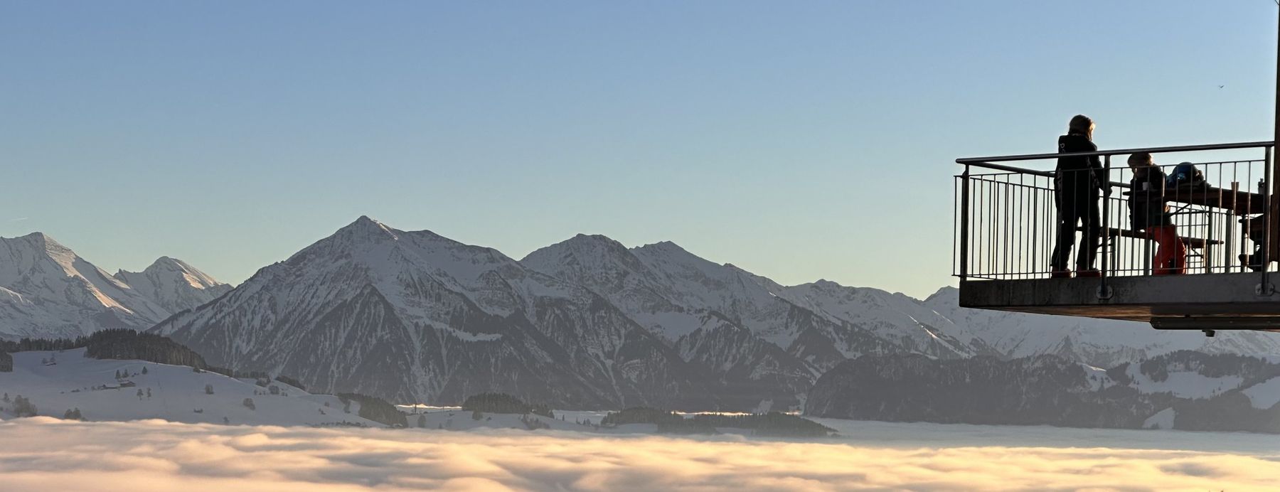 Terrasse über dem Nebelmeer im Abendlicht, dahinter die Berner Alpen